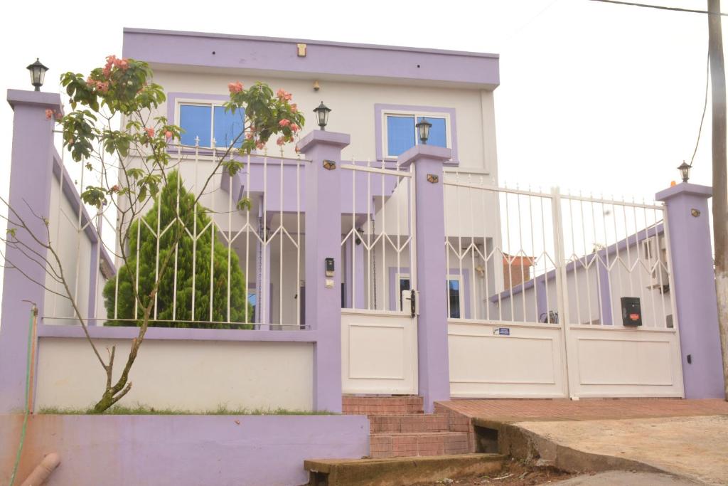 a house with a purple fence and a gate at Polgaro duplex luxueux in Douala