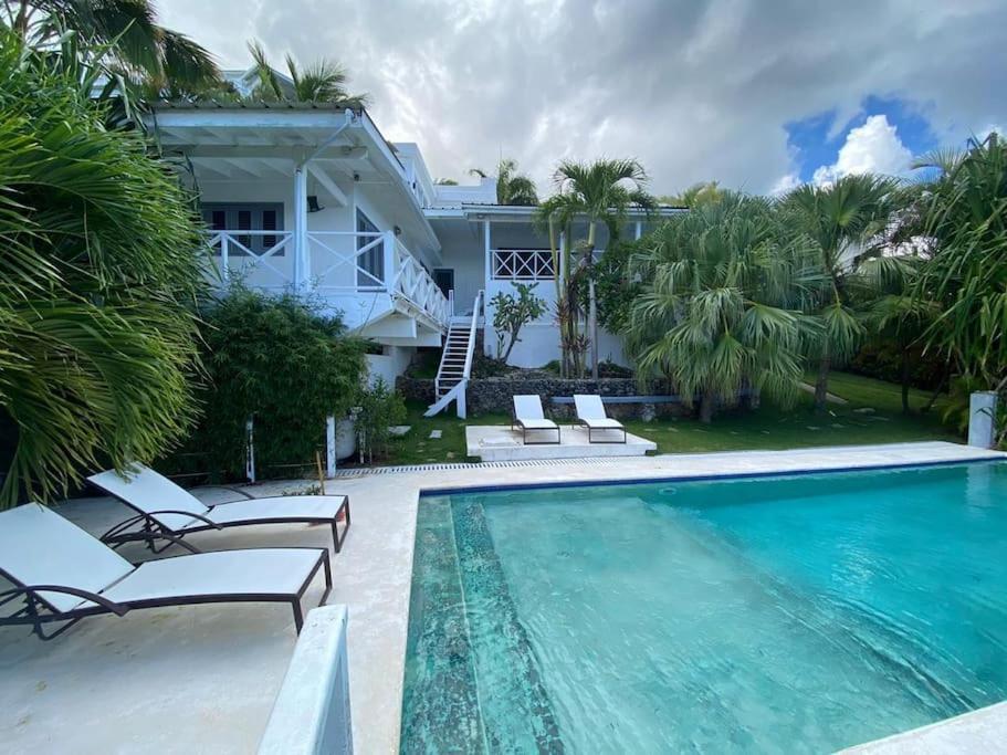 a swimming pool in front of a house at Spectacular Cozy Sea View Staffed Villa in Las Terrenas