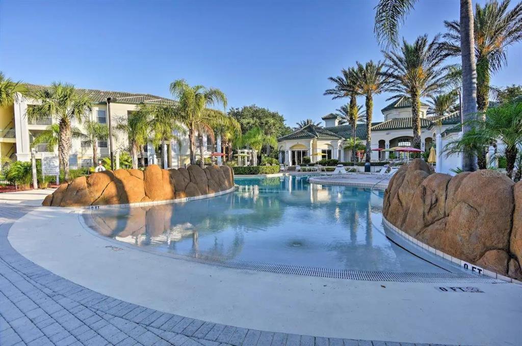 een zwembad in een resort met palmbomen bij Luxury Apartment near Disney and other Theme parks in Kissimmee
