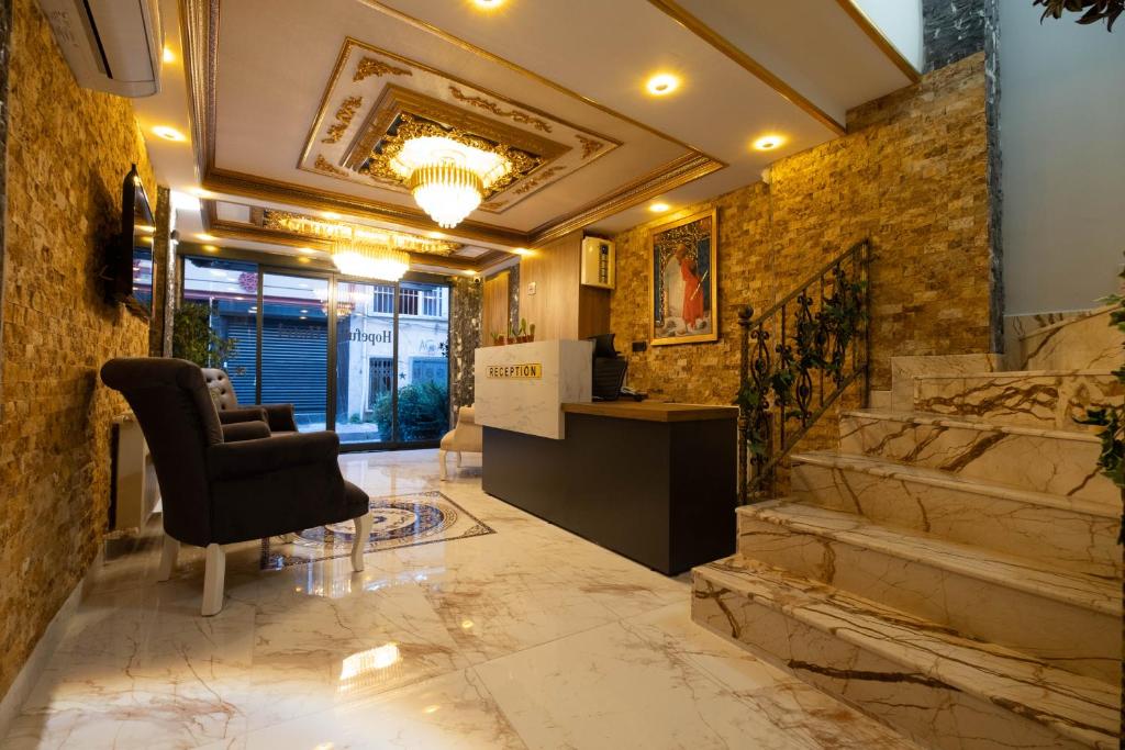 un vestíbulo con una silla y escaleras en un edificio en HOPEFULL HOTEL, en Estambul