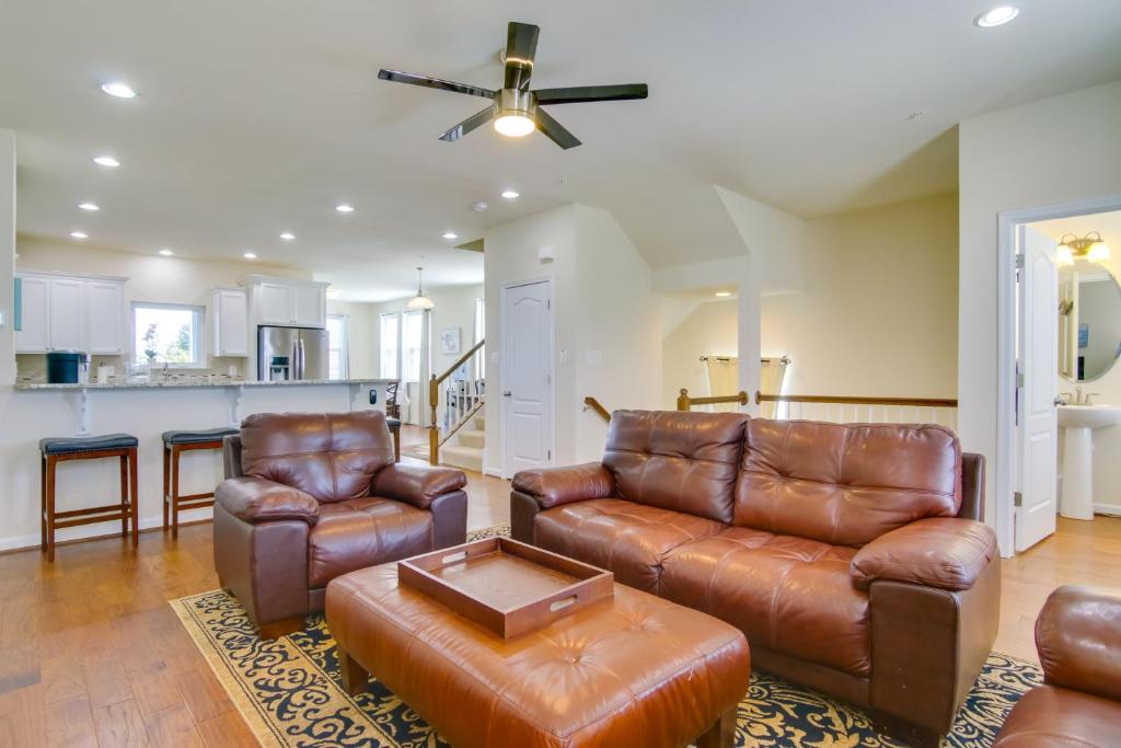a living room with leather furniture and a kitchen at Luxury Ocean City Retreat with Beautiful Bay Views in Ocean City