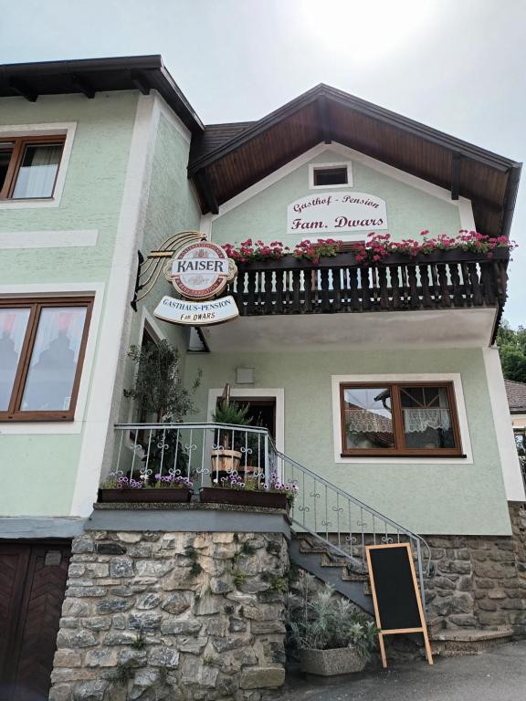 a building with a balcony and flowers on it at Gästehaus-Pension Familie Dwars in Spitz