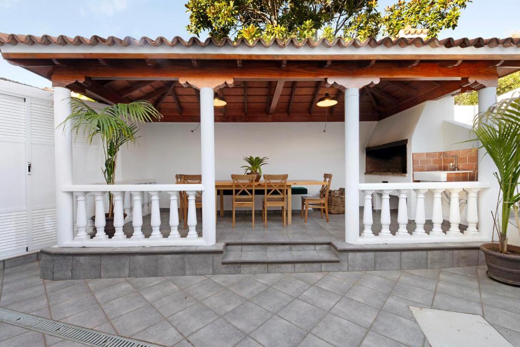een patio met een tuinhuisje met een tafel en een eetkamer bij Casa Camino La Estrella in Breña Alta