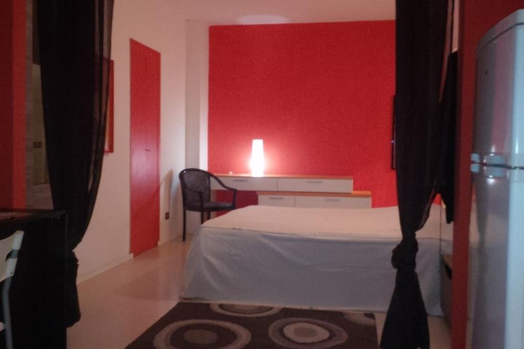 雷焦艾米利亞的住宿－punto G，一间卧室设有一张床和红色的墙壁