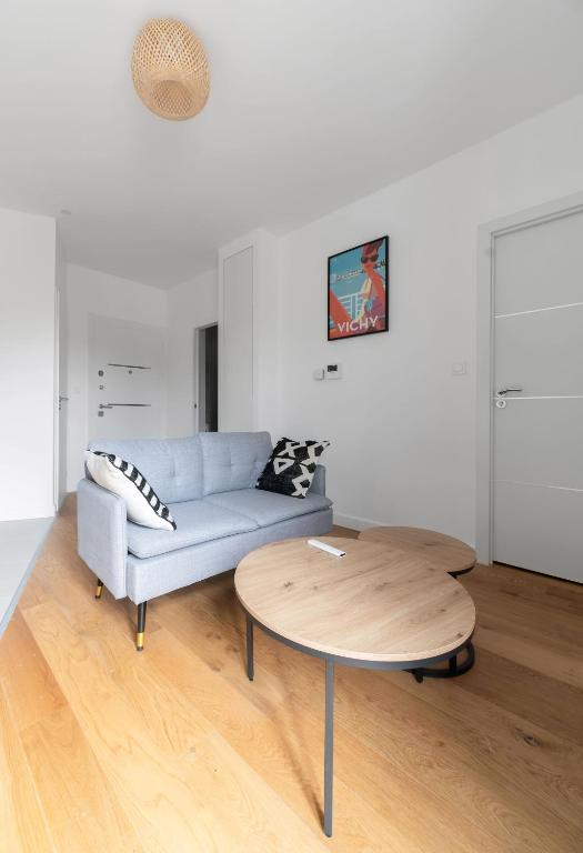 a living room with a couch and a coffee table at Le Royal - Appartement design - Hyper centre in Vichy