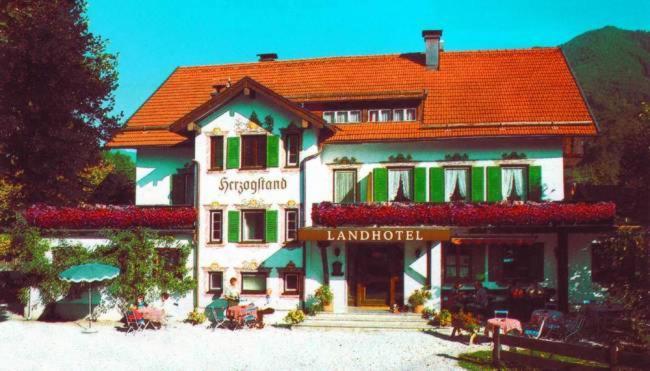 un gran edificio blanco con techo rojo en Landhotel Herzogstand Garni, en Kochel