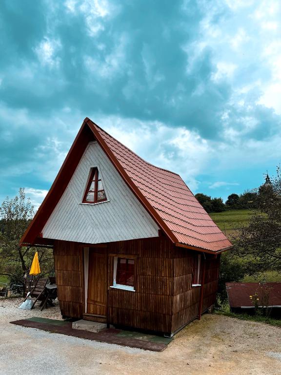 uma pequena cabana com um telhado vermelho em Koča Janka in Metke em Velika Loka