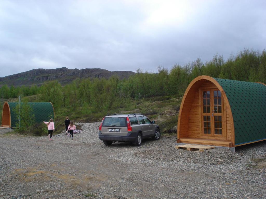 un coche aparcado delante de una casa pequeña en Vinland Camping Pods en Egilsstadir