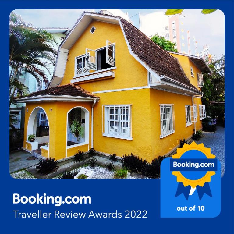 a yellow house with the words boatingcon traveller review awards at Casa Amarela Blumenau Hospedagem Alternativa in Blumenau