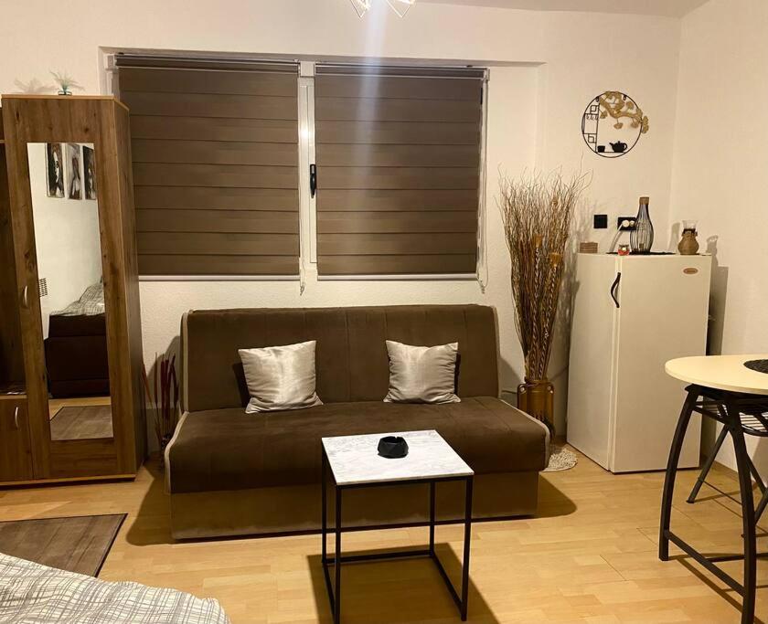 uma sala de estar com um sofá e uma mesa em Apartman Fany em Saraievo