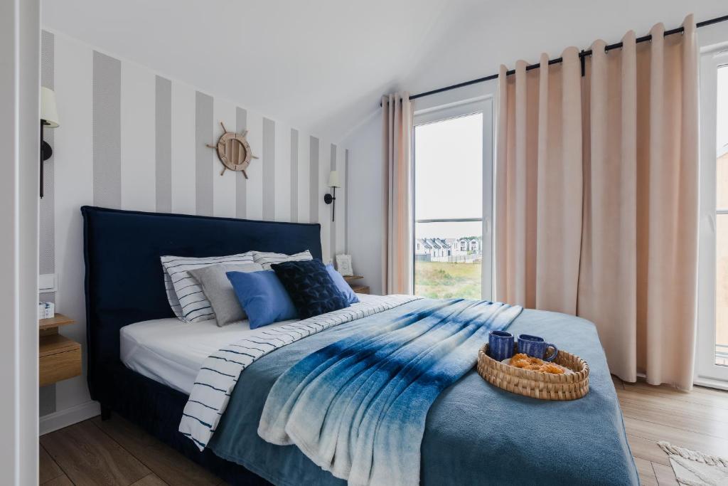 Un dormitorio con una cama azul con una cesta. en Mia Mare A & B Jastrzębia Góra, en Jastrzębia Góra