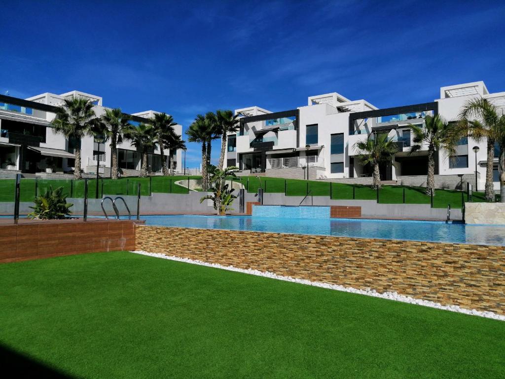 um resort com uma piscina em frente a alguns edifícios em Oasis Beach VIII Punta Prima 3023 em Torrevieja