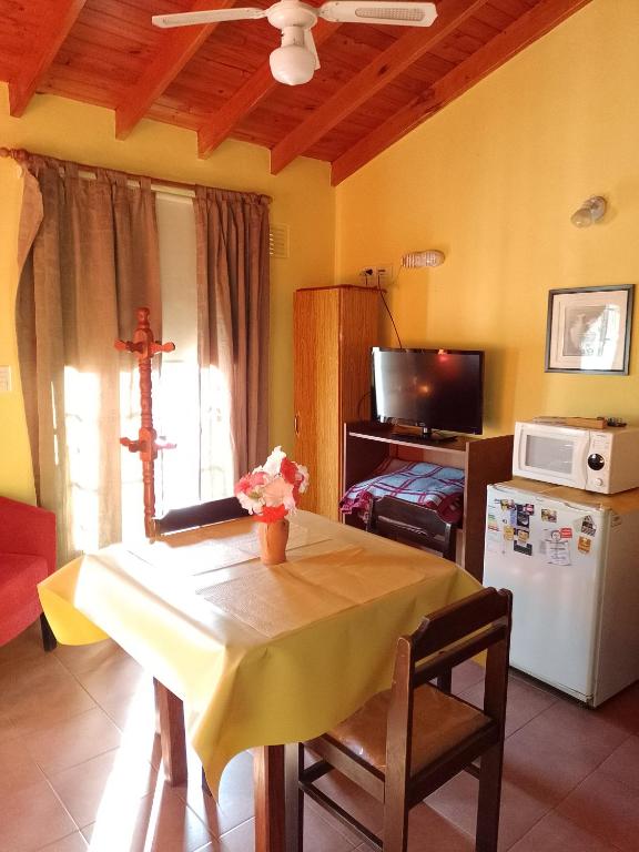 a room with a table and a kitchen with a microwave at Aparts Altos del Centro in Merlo