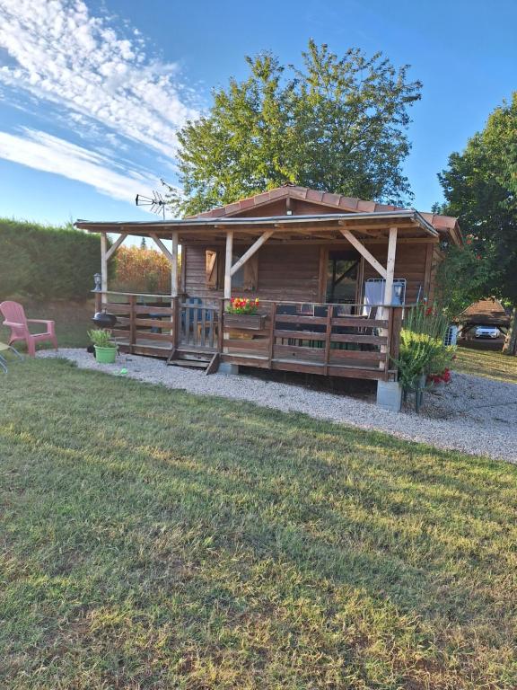 a log cabin with a porch and a bench at Le chalet douillet in Saint-Geniès