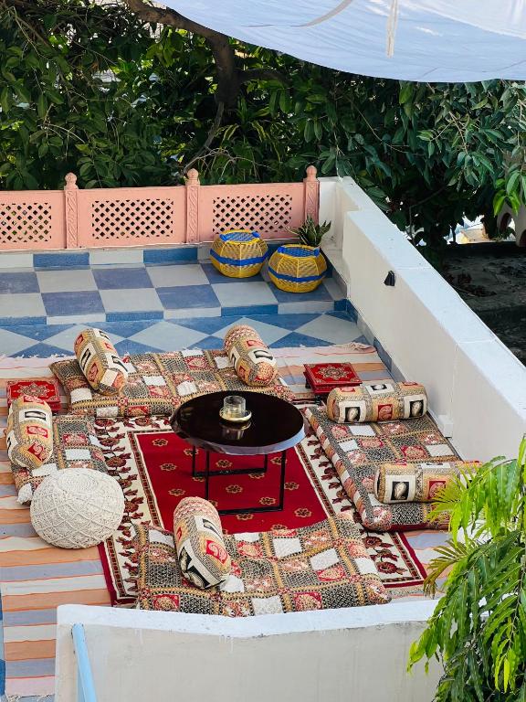 a patio with a table and chairs on a tile floor at Ferozi House - A boutique Homestay in Jaipur