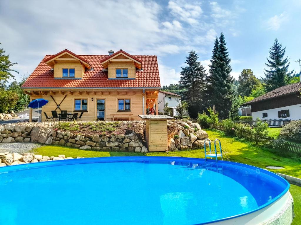 uma casa com piscina em frente a uma casa em Holiday Home Chalet Sven by Interhome em Spiegelau