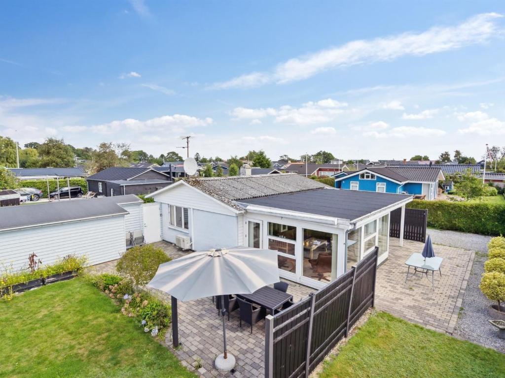 a white house with an umbrella in a yard at Holiday Home Mena - 200m from the sea by Interhome in Børkop