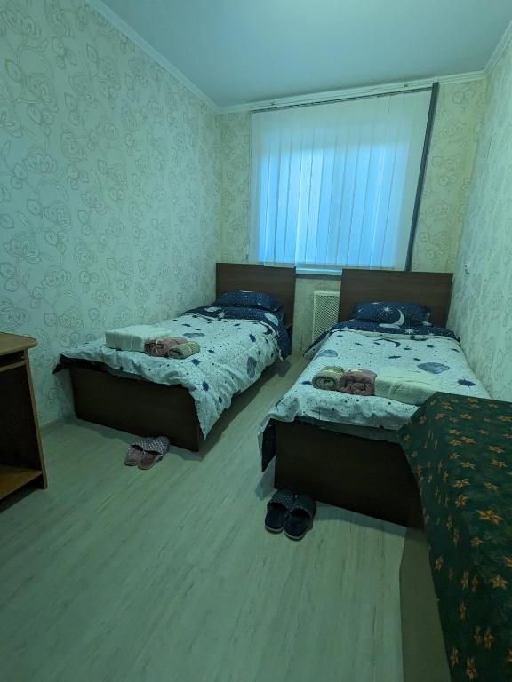 dwa łóżka w sypialni z butami na podłodze w obiekcie Apartament motel w Kiszyniowie