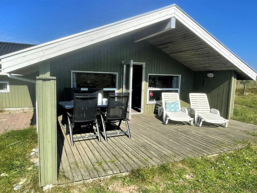 um deque com uma mesa e cadeiras em Holiday Home Juha - from the sea in Western Jutland by Interhome em Bjerregård