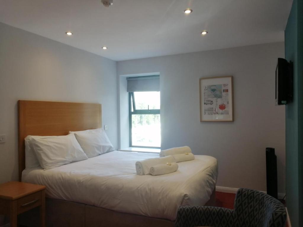 a bedroom with a bed with two towels on it at Newlands Holidays in Bridport