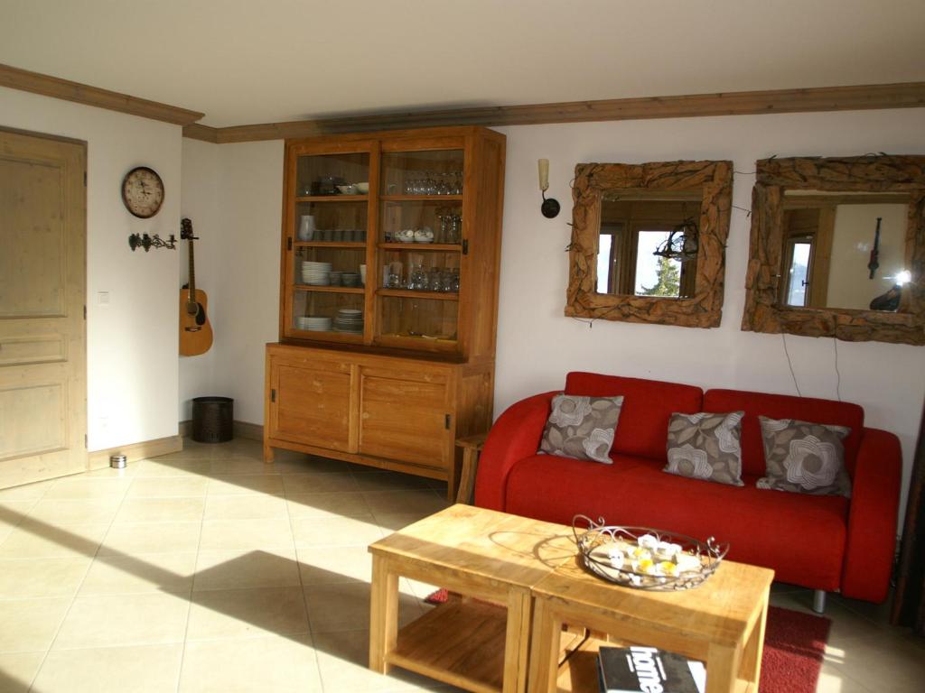 uma sala de estar com um sofá vermelho e uma mesa em Appartement Les Adrets-Prapoutel, 4 pièces, 8 personnes - FR-1-557-15 em Les Adrets
