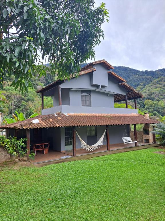 una casa con una hamaca en el patio en Recanto São Romão en Nova Friburgo