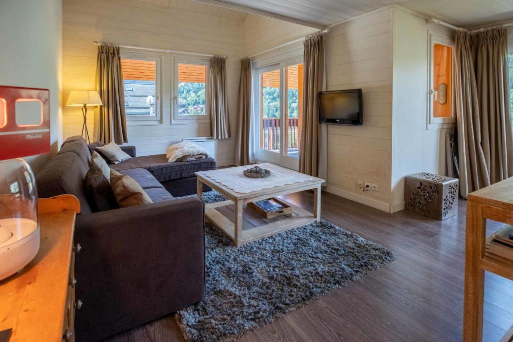 un salon avec un canapé et une table dans l'établissement Cybeles 8, à Méribel