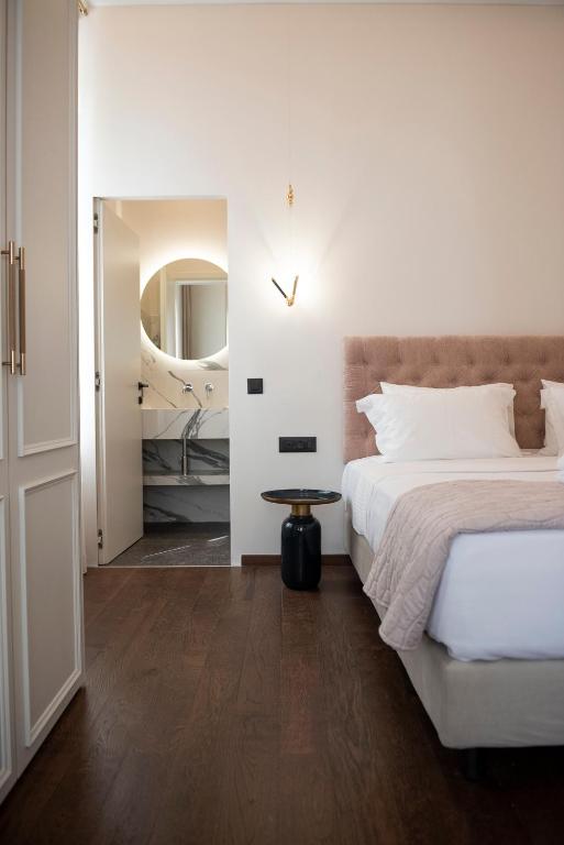 a bedroom with a large bed and a mirror at Jensen Luxury Suites in Rhodes Town
