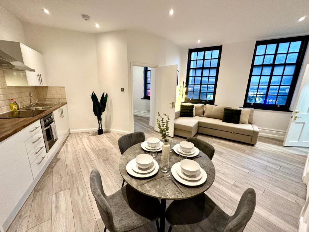 a kitchen and living room with a table and chairs at Modern 1-Bedroom Apartments in Shoreditch, Old Street in London