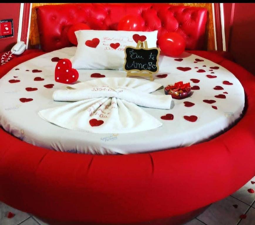 a red bed with hearts and a sign on it at Via canal 1 in Brasília