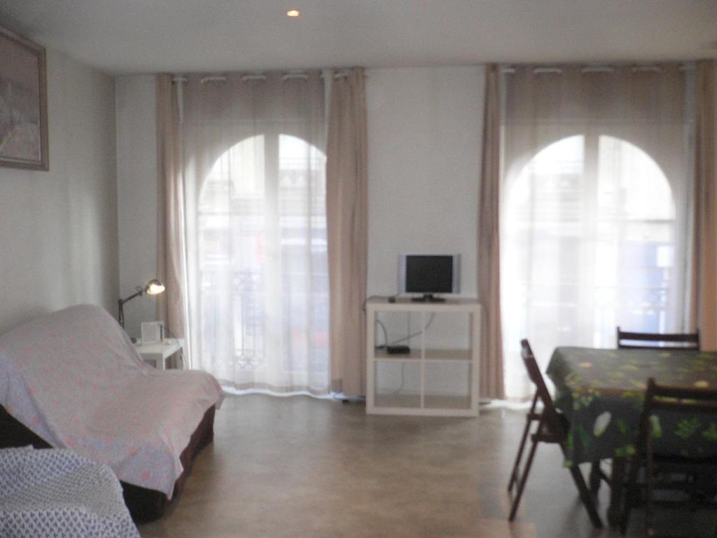 una camera da letto con due finestre, un letto e un tavolo di Vieux Marché - Centre historique a Rouen