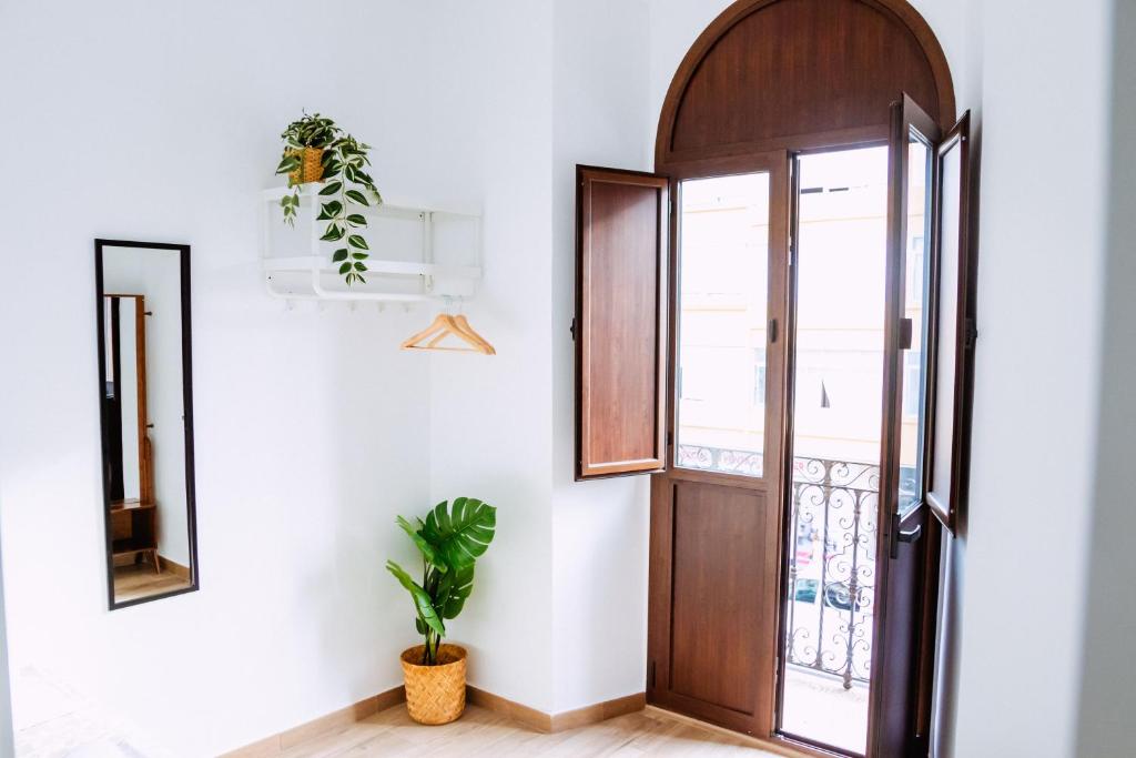 a hallway with a wooden door and a plant at Triana Riverside in Seville