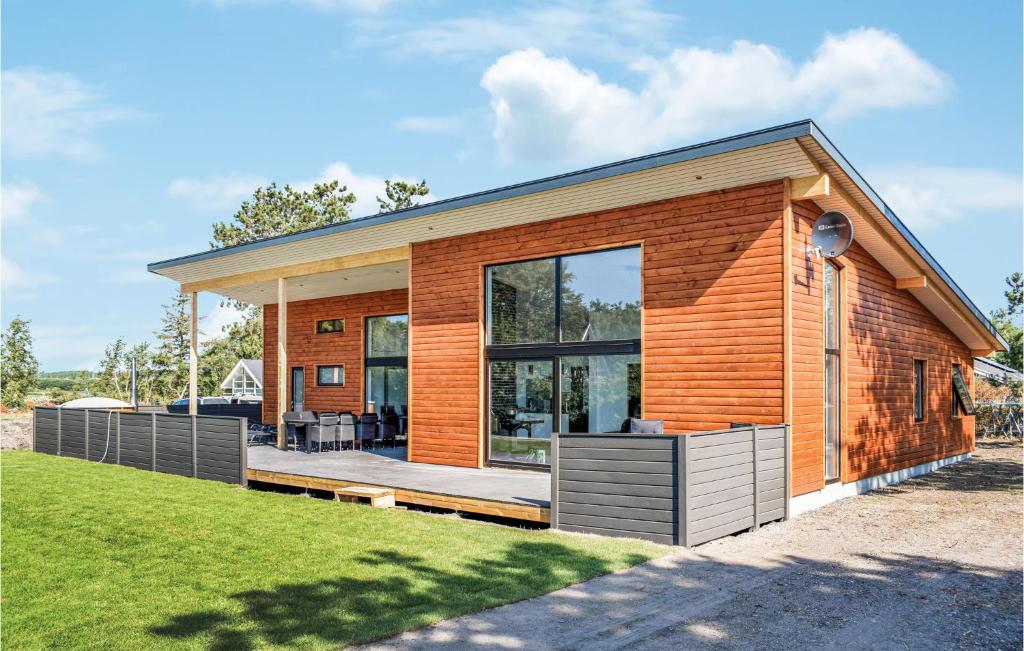 エーベルトフトにあるAmazing Home In Ebeltoft With 4 Bedrooms, Sauna And Wifiの大きなガラス戸のある木造家屋
