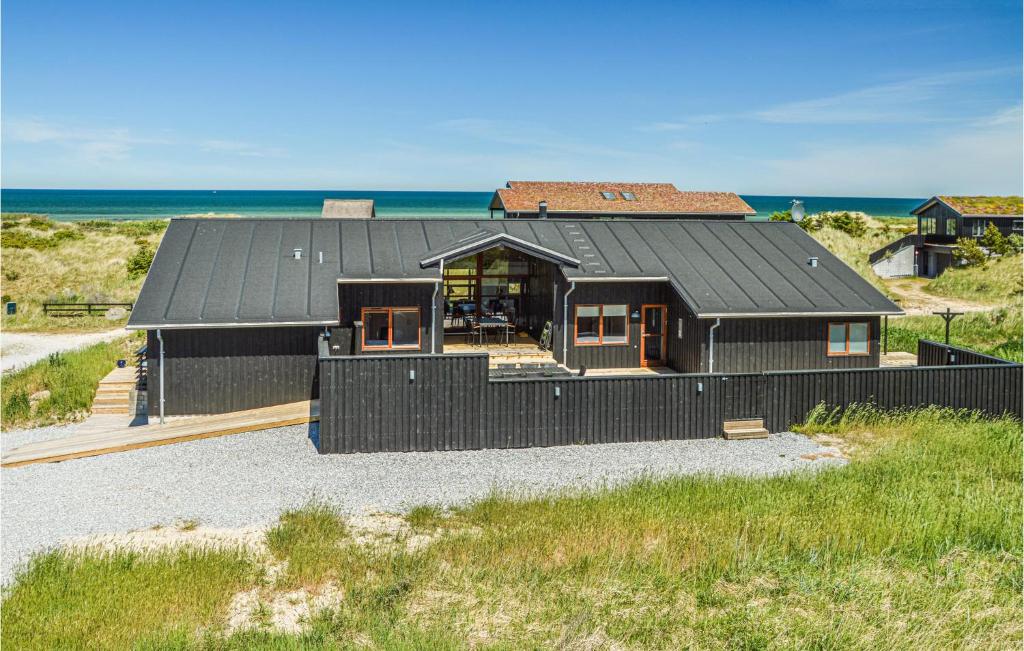 una casa negra con techo negro en la playa en Lovely Home In Hirtshals With House Sea View, en Hirtshals