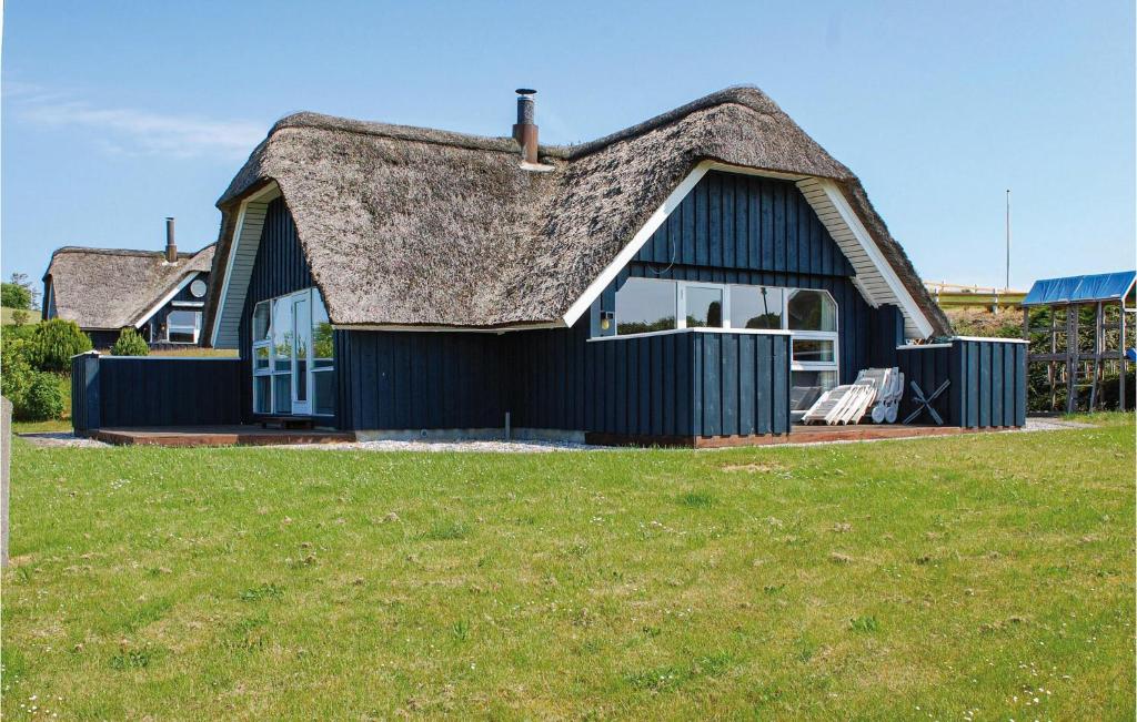 エーベルトフトにあるStunning Home In Ebeltoft With Kitchenの茅葺き屋根の小さな黒い家