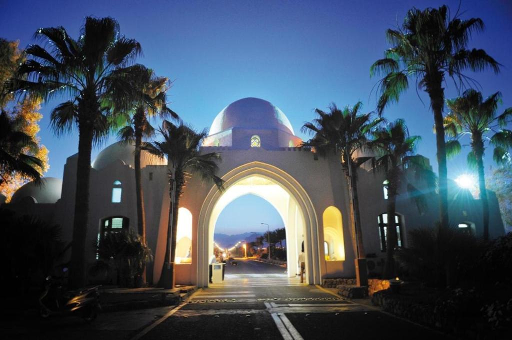 Una mezquita con palmeras delante. en GRACE HOUSE DOMINA CORAL BAY en Sharm El Sheikh