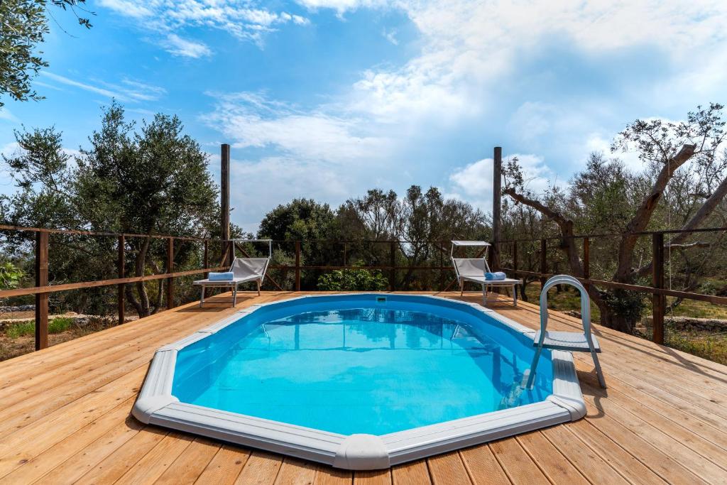 una piscina su una terrazza con due sedie di Villetta Li pipili ad Andrano