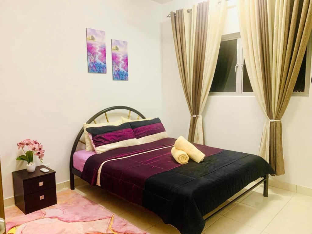 um quarto com uma cama com lençóis e almofadas roxos em UMAR HOMESTAY - Alanis KLIA em Sepang
