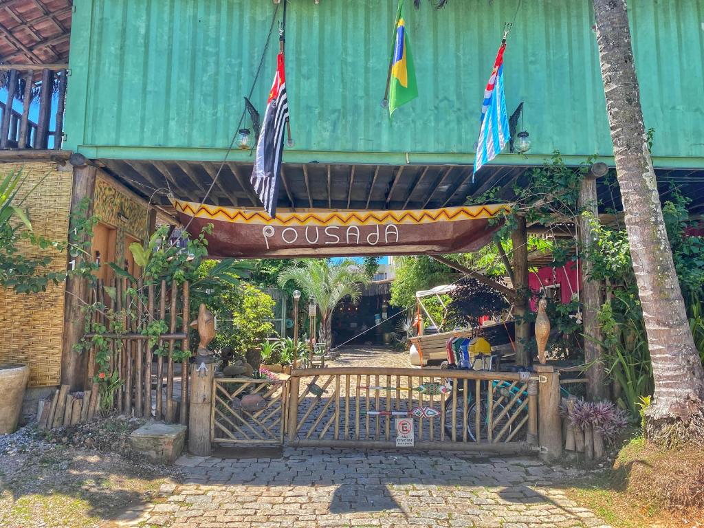 a wooden gate with a sign that reads pokhtar at Pousada Papaya Container in Ubatuba