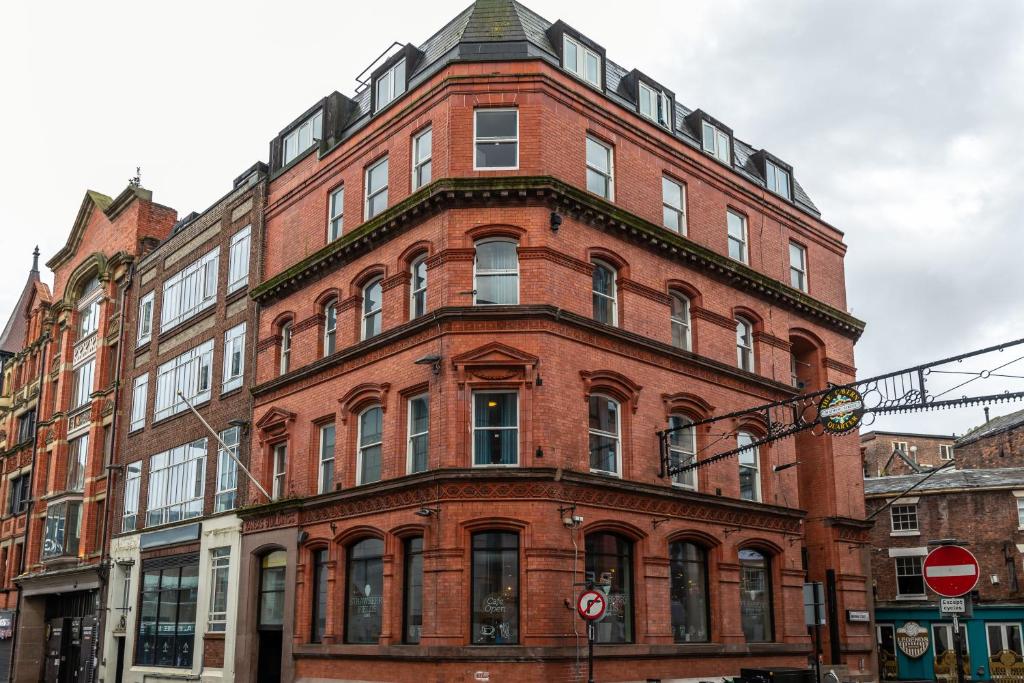 un grande edificio in mattoni rossi su una strada cittadina di Kabannas Liverpool a Liverpool