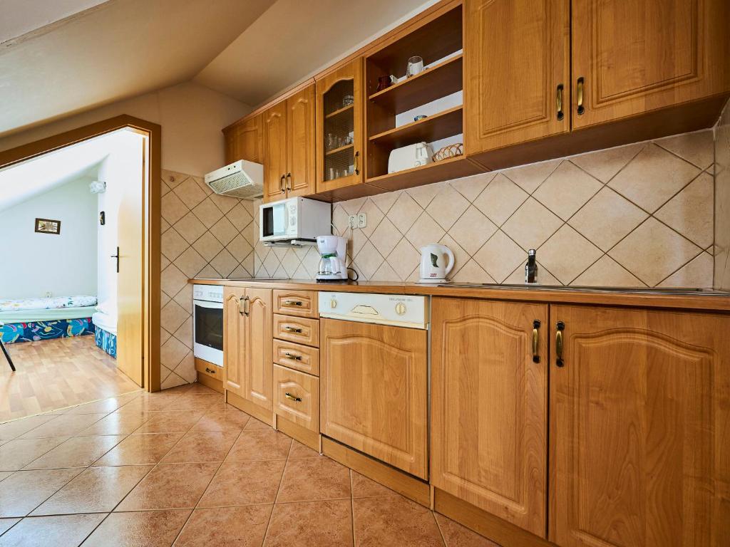 a kitchen with wooden cabinets and a tile floor at Apartment Harrachov 497-2 by Interhome in Harrachov