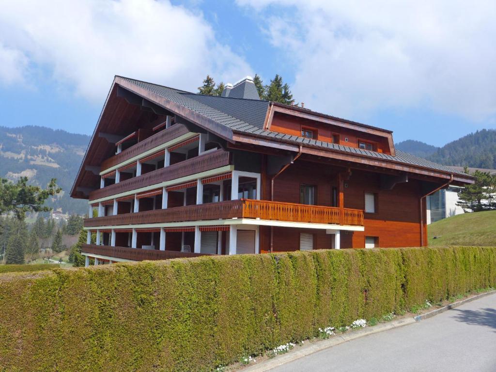 una casa en una colina junto a un seto en Apartment Hyacinthe 14 by Interhome, en Villars-sur-Ollon