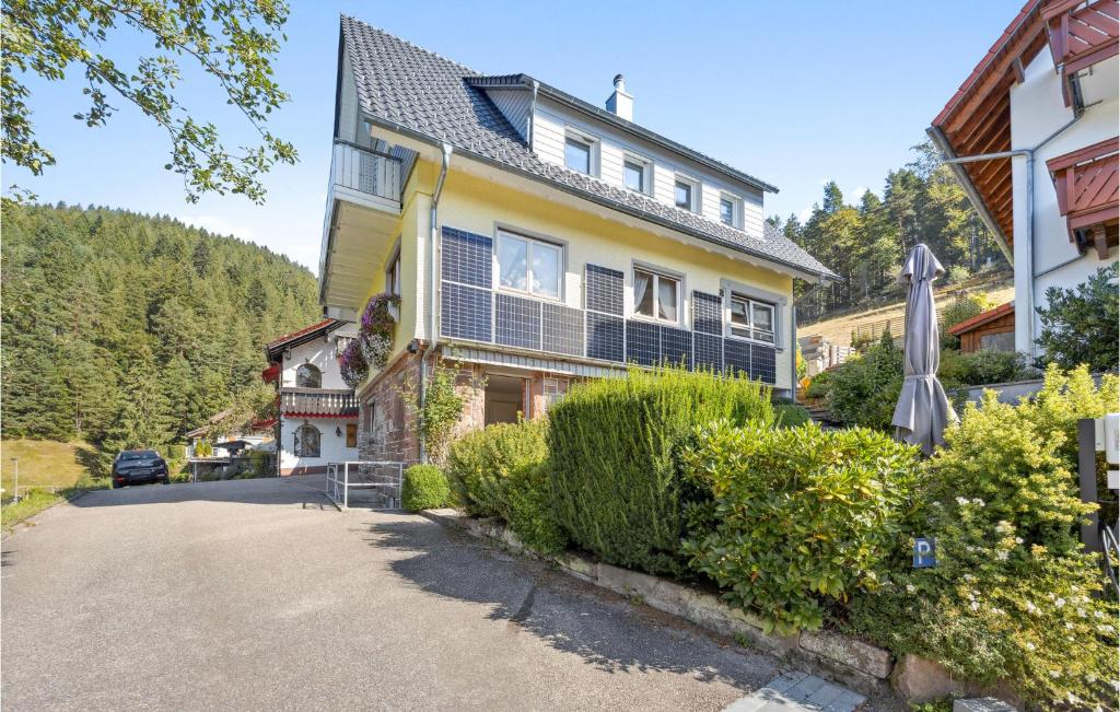 une maison dans les montagnes avec un parasol dans l'établissement Fewo Mitteltal, à Baiersbronn