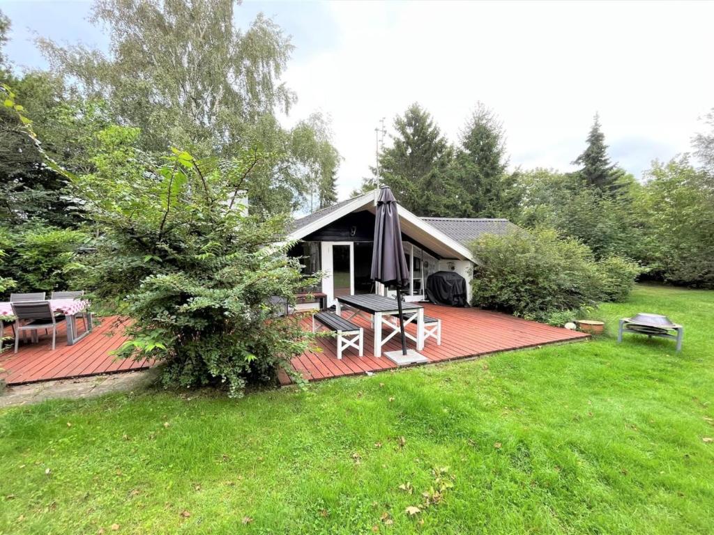 ein Haus mit einer Terrasse mit einem Tisch und Stühlen in der Unterkunft Holiday Home Ninni - 3-2km from the sea in Sealand by Interhome in Eskebjerg