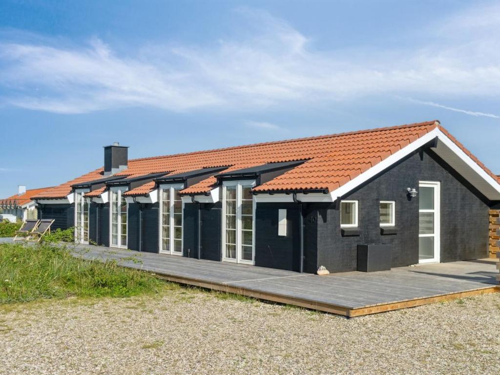 een zwart huis met een oranje dak bij Holiday Home Blaguna - 600m from the sea in NW Jutland by Interhome in Torsted