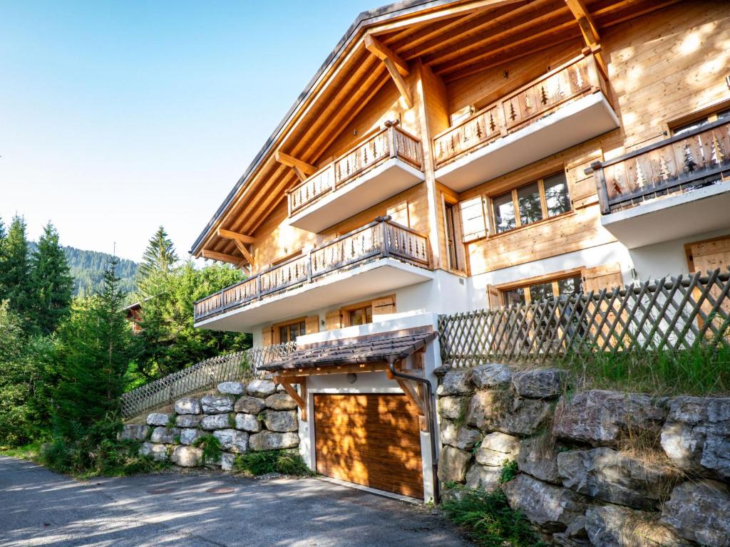 a large house with a stone wall and a fence at Chalet Dipankar by Interhome in Villars-sur-Ollon