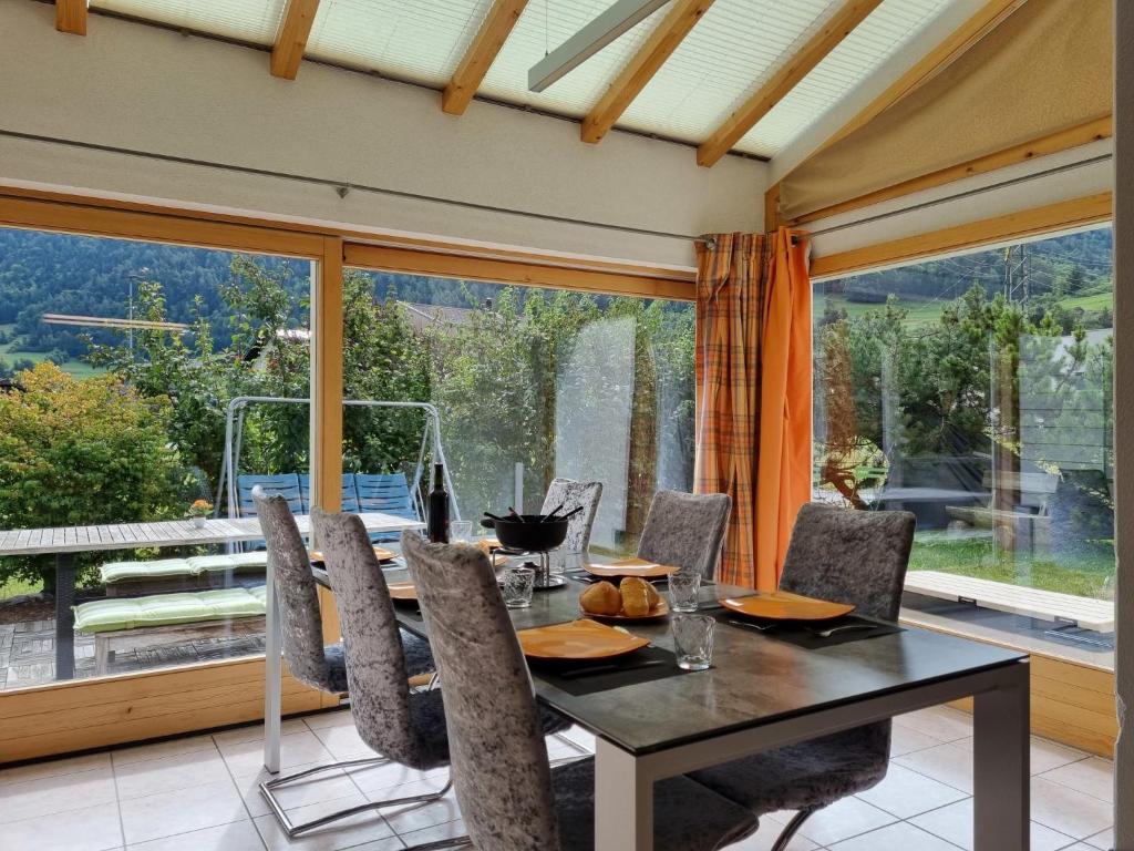 comedor con mesa y sillas y ventana grande en Holiday Home Le Chant de la Dranse by Interhome, en Sembrancher