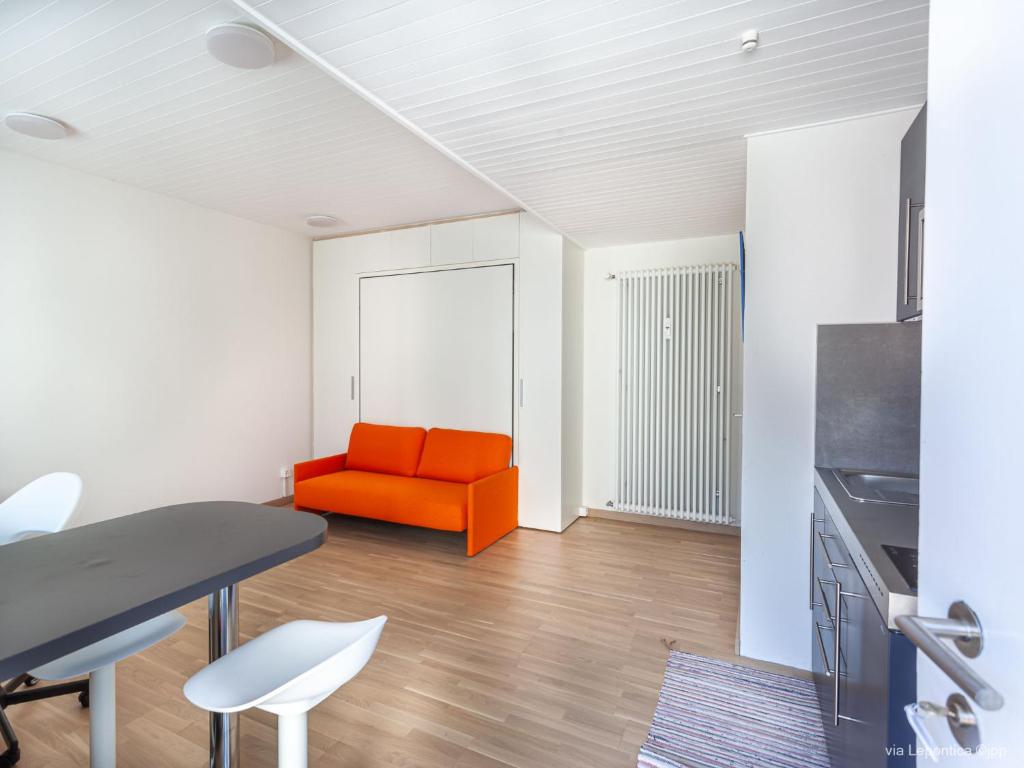 - un salon avec un canapé orange et une table dans l'établissement Studio Casa Lepontica-1 by Interhome, à Leontica