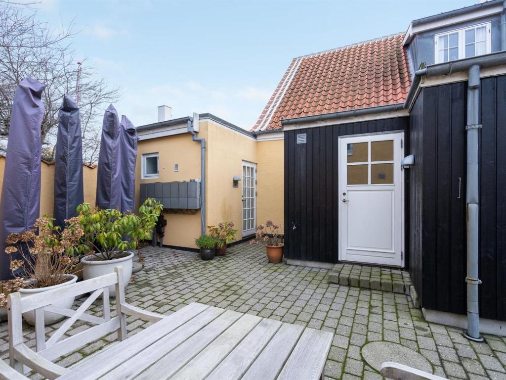 a backyard with a black shed and a white door at Apartment Marisol - 700m from the sea in NW Jutland by Interhome in Skagen