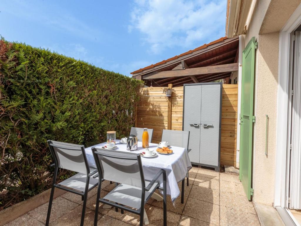 a table and chairs on the patio of a house at Holiday Home Les Jardins de la Palmyre-2 by Interhome in Les Mathes